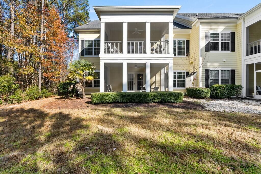 A two-story house with a covered front porch, a small garden, and a driveway.