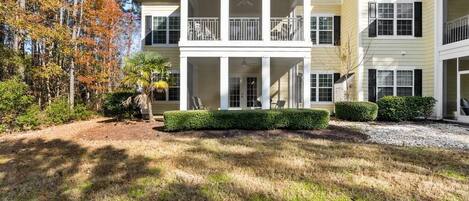A two-story house with a covered front porch, a small garden, and a driveway.