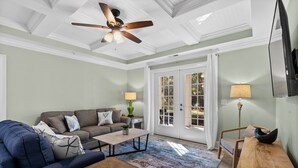 A spacious living room with a ceiling fan, a sofa, a coffee table, and a wooden side table. - Golfer's Getaway Condo- Players Village TPC (Murrells Inlet)