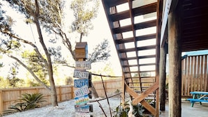 Une structure de pergola en bois sur laquelle est accroché un panneau présentant différents modèles de plaques d’immatriculation.