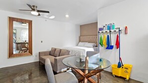 A modern bedroom with a bed, a sofa, a glass table, and a ceiling fan. - +MS +Loft Extraordinario  +Cómodo +Internet (Santiago de Querétaro)