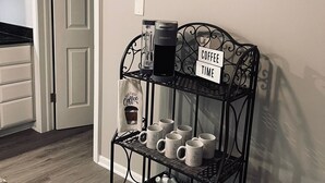 Eine Küche mit einer Kaffeestation, einschließlich einer Kaffeemaschine, Tassen und einem Schild mit der Aufschrift 'Coffee Time'.