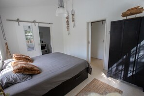 Ein Schlafzimmer mit einem Bett, einem Kleiderschrank und einer Pendelleuchte.