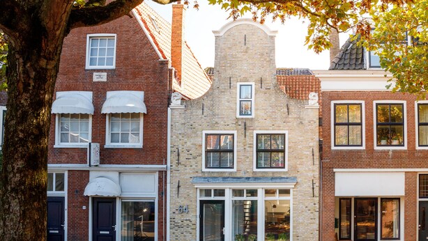 En række traditionelle murstensbygninger med store vinduer og et centralt tårn.