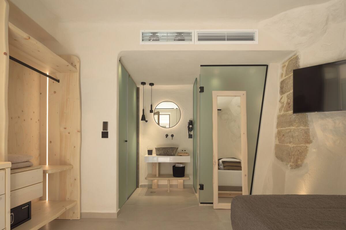 A modern bathroom with a wooden vanity, a sink, and a mirror.