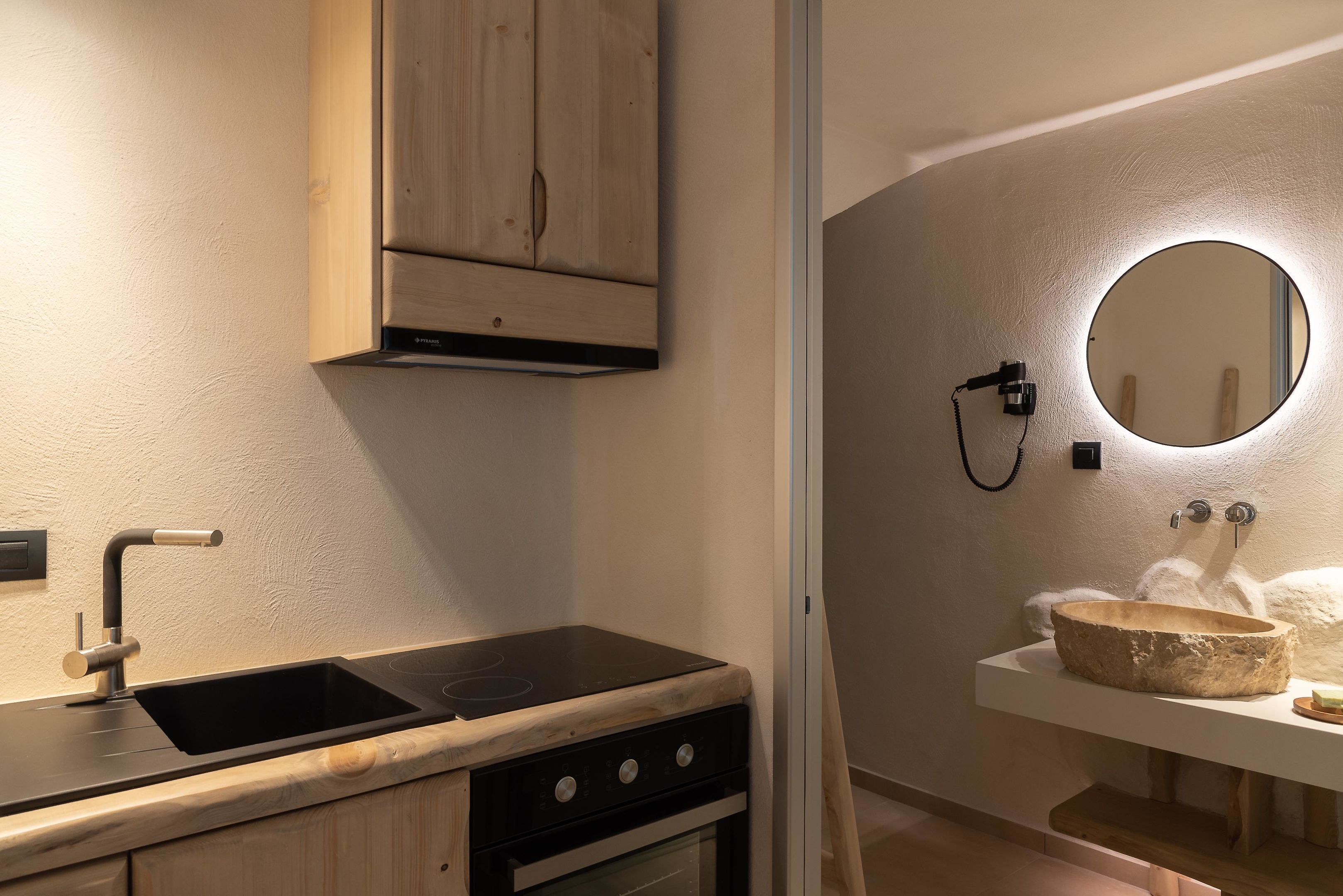Una cocina moderna con estufa negra, pileta y muebles de madera.