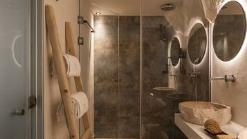 Un bagno moderno con cabina doccia in vetro, una scala in legno e uno specchio grande.