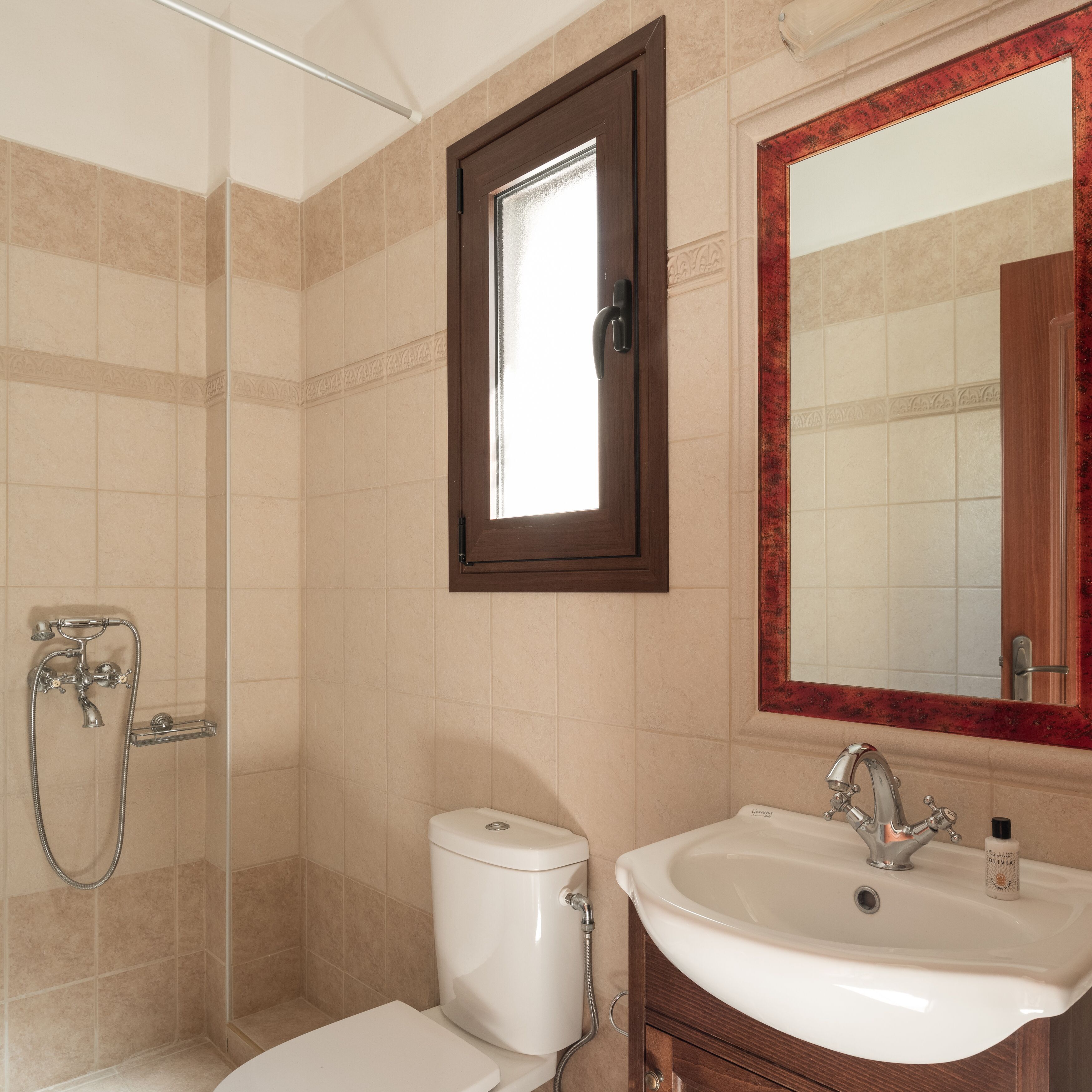 A bathroom with a toilet, sink, and shower.