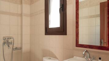 A bathroom with a toilet, sink, and shower.