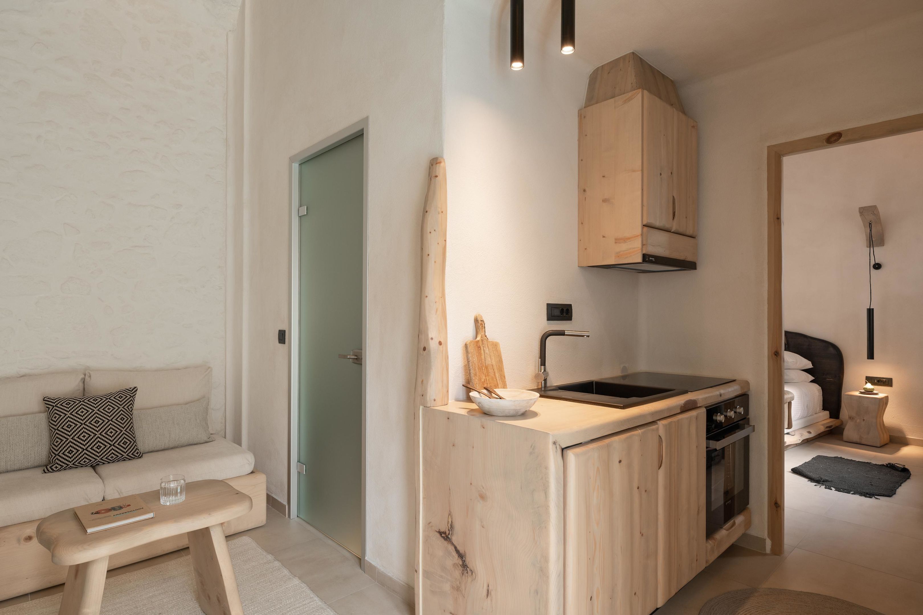 Een kleine keuken met een houten aanrecht, een ingebouwde oven en een spoelbak.