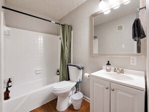Une salle de bain avec une baignoire, des toilettes, un lavabo et un miroir.