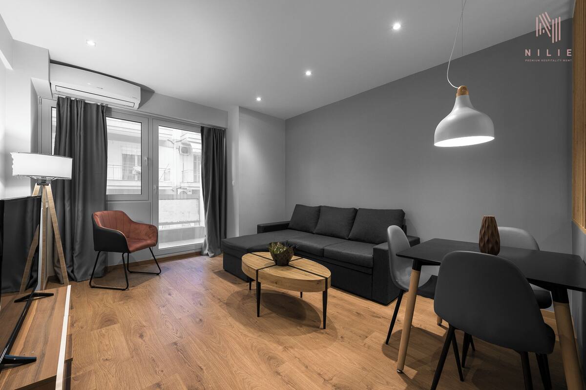 Una sala moderna con un sofá, una mesa de centro y una mesa de comedor con sillas.