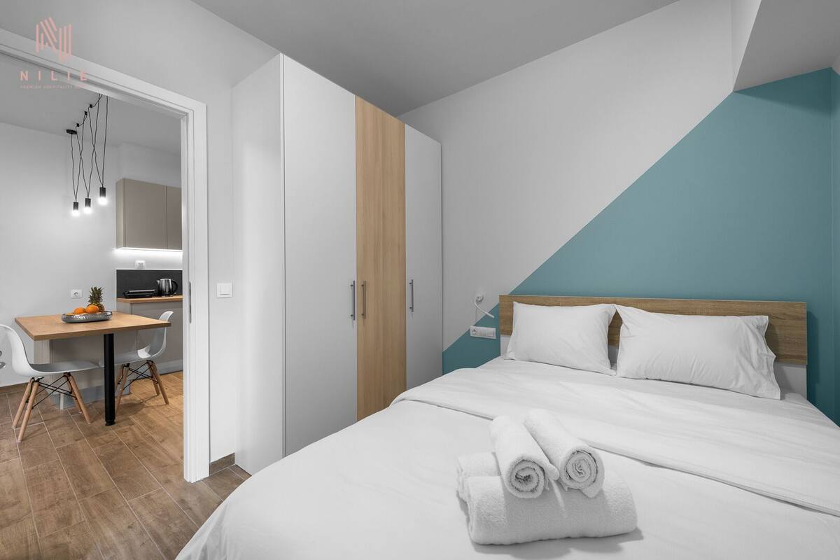 Una habitación de hotel moderna con cama, escritorio y kitchenette.