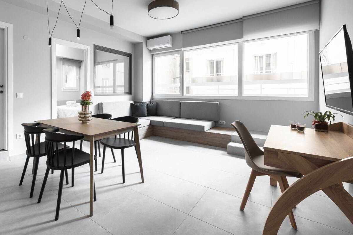 Una cocina moderna con comedor, sofá y televisor.