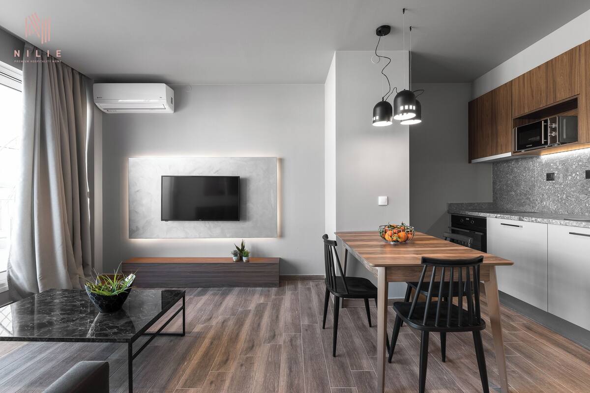 Una cocina moderna con microondas integrado, armarios de madera y encimera de granito.