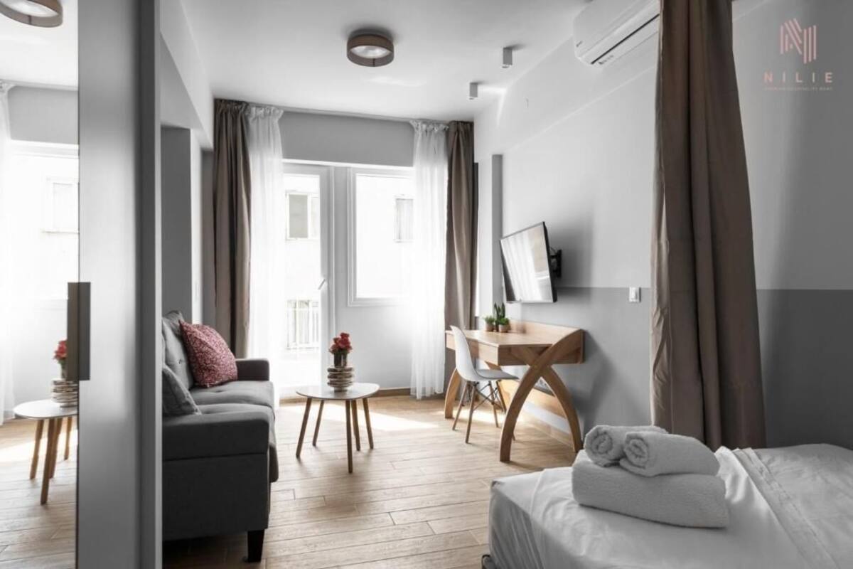 Ein modernes Hotelzimmer mit Bett, Schreibtisch, Sofa und Esstisch.