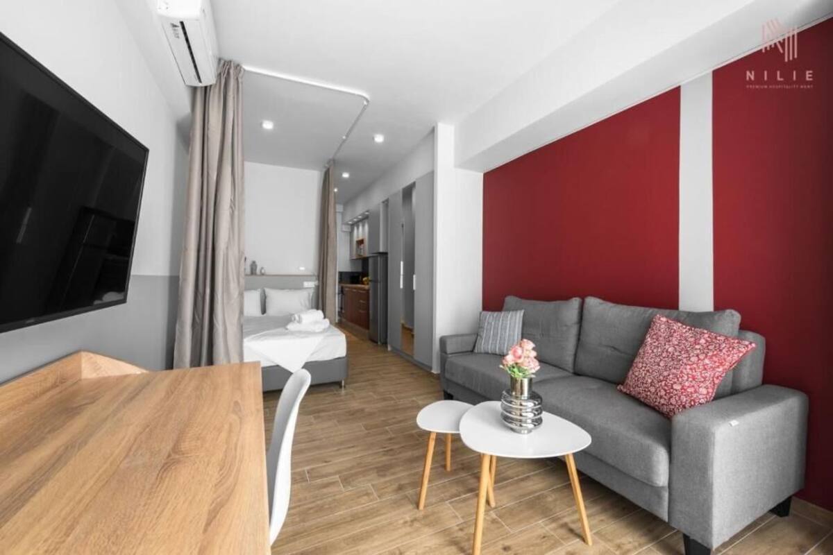 Ein modernes Wohnzimmer mit einem grauen Sofa, einem weißen Couchtisch und einem Holzessttisch.