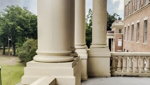A view of a building's exterior with large columns and a brick facade.