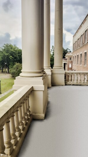A view of a building's exterior with large columns and a brick facade.
