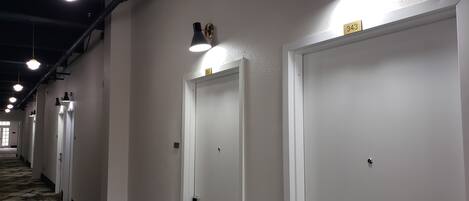 Un pasillo con puertas blancas, cada una con un número.