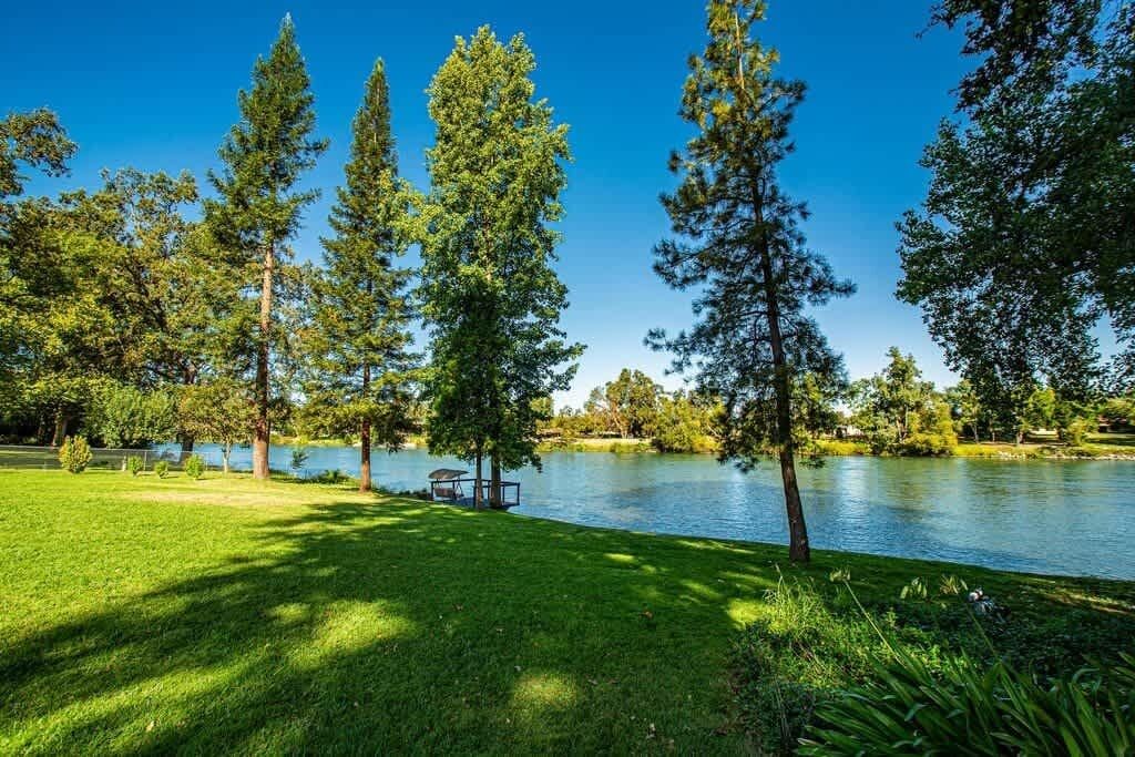 Un parque con un lago, árboles y un banco.