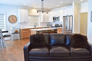 Relax in this stylish living space with a sofa, dining area, and fully equipped kitchen.