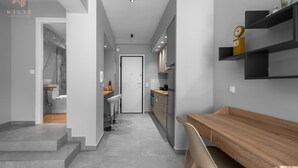 Une cuisine moderne avec une table et des chaises en bois, un four encastré et un réfrigérateur.