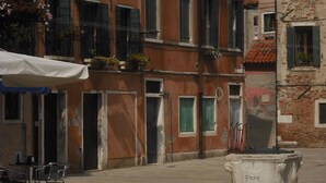 A street scene with a building featuring multiple windows, some with shutters, and a trash bin labeled "FREE" in the foreground. - Elegant and modern flat, historical centre wi-fi M0270422272 (Venezia)