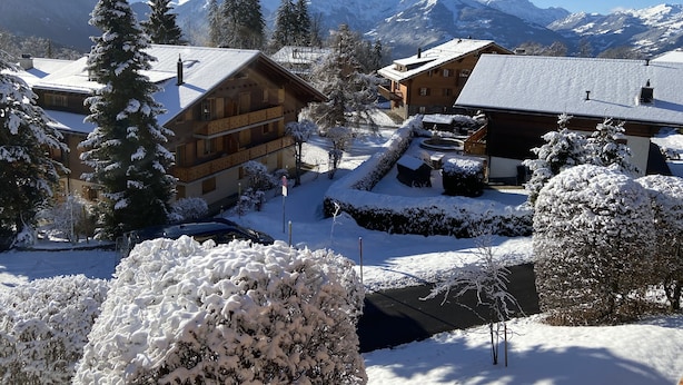 Un pueblo cubierto de nieve con edificios de madera y una vista despejada de los picos circundantes.