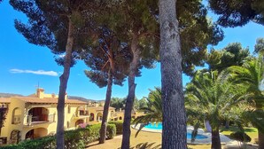 A Mediterranean-style villa with a swimming pool, surrounded by mature trees and well-maintained gardens. - Casa Alta Apartment, Moraira, with 2 large community pools (Moraira)