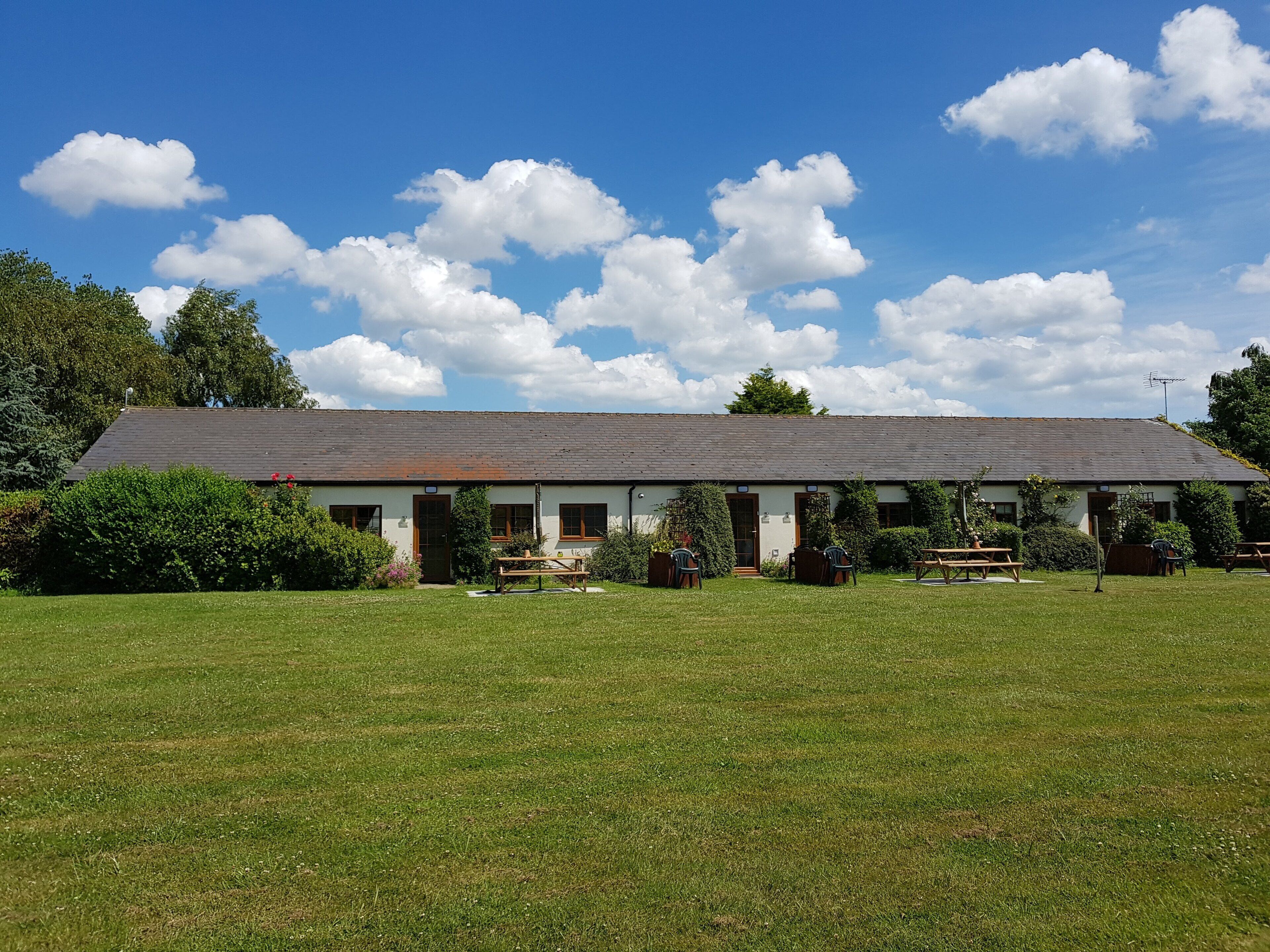 A single-story building with a sloped roof, surrounded by a well-maintained lawn.
