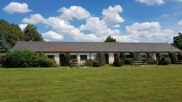 A single-story building with a sloped roof, surrounded by a well-maintained lawn.