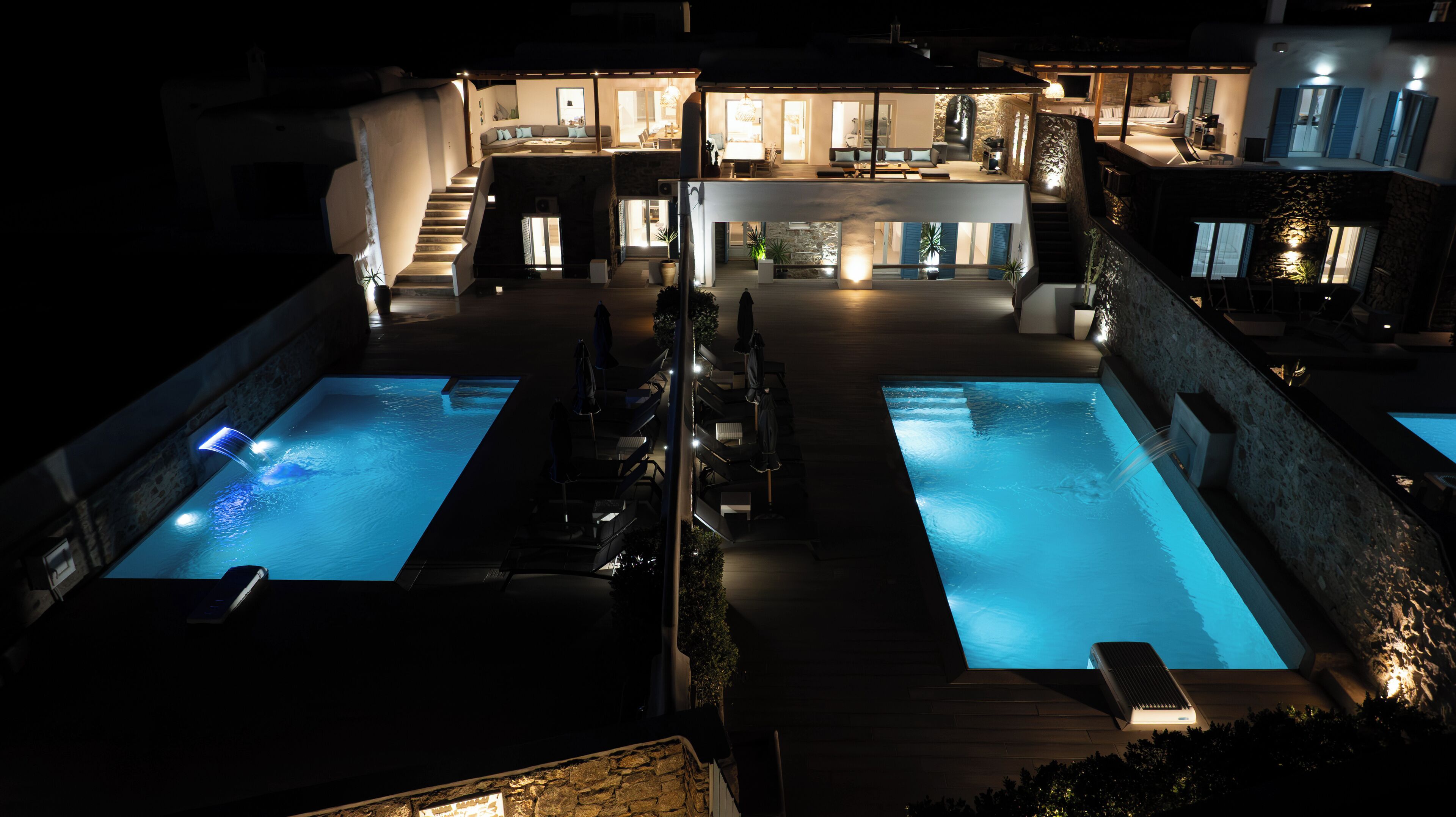 Un espace extérieur luxueux doté de deux piscines, d’un bar et d’un coin salon.