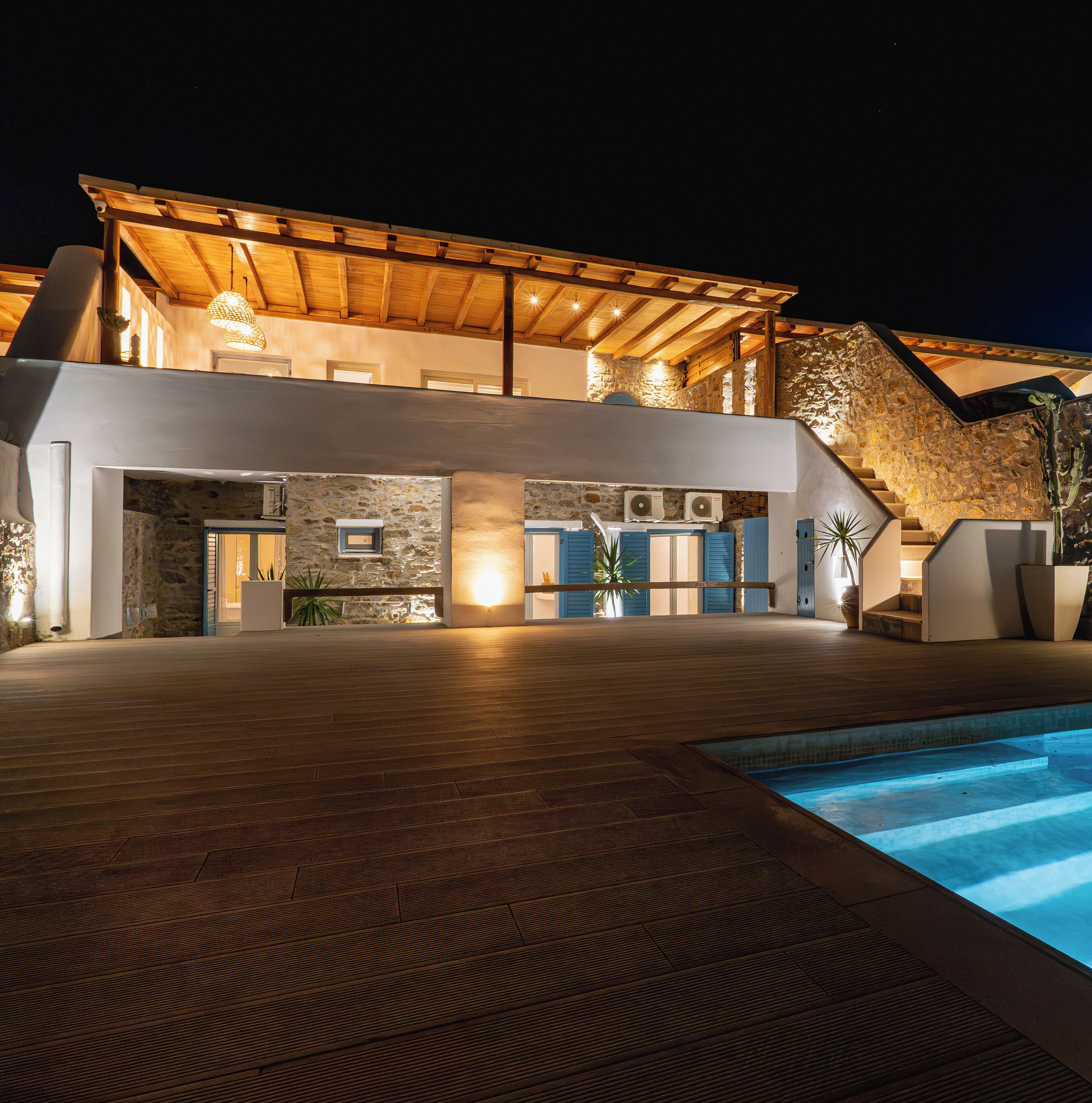 Ein modernes Gebäude mit Pool, Steinmauern und Holzbalken.