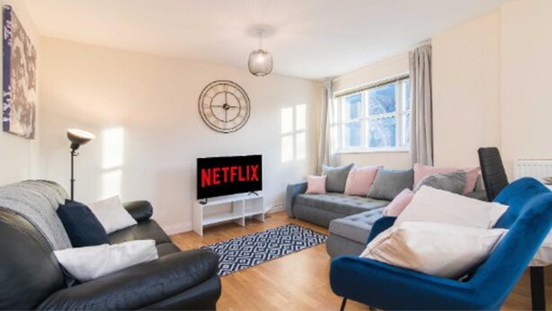 A modern living room with a flat-screen TV, two sofas, a coffee table, and a patterned rug. - Sublime Stays Parliament 2-bed Apartment (Derby)