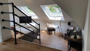 A modern loft bedroom with a skylight, a bed, a desk, and a chair. - Boutique Hotel Villa Horbach (Idar-Oberstein)