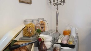 A breakfast buffet with various pastries, muffins, and a candelabra. - Boutique Hotel Villa Horbach (Idar-Oberstein)