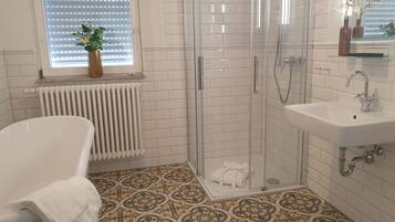 A bathroom with a shower, a sink, and a bathtub.