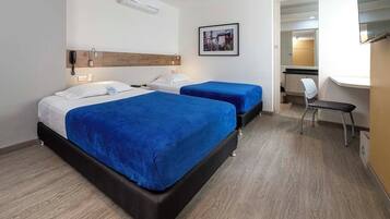 A hotel room with two beds, a desk, and a chair.