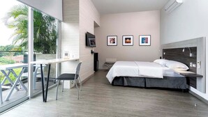 A modern hotel room with a balcony, a bed, a desk, and a TV. - Hotel Park 85 (Cali)