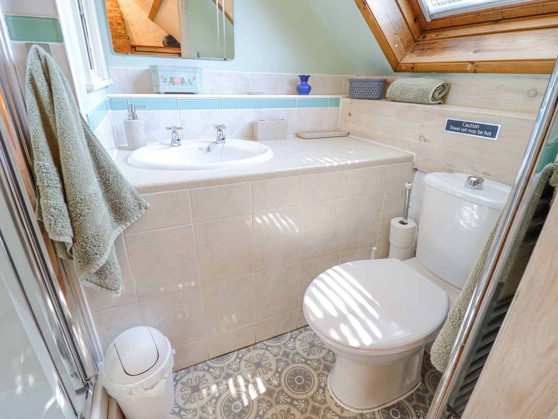 A compact bathroom with a sink, toilet, and a towel rack.