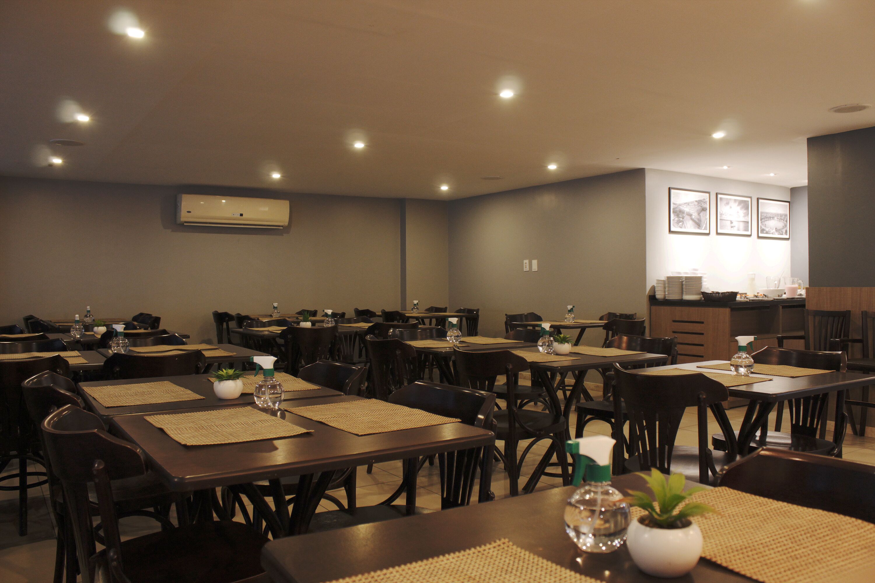Un comedor con varias mesas y sillas, dispuesto en un espacio amplio.