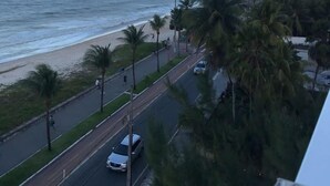 Una carretera costera con playa y palmeras.