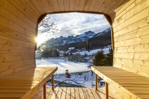 A wooden cabin with a balcony overlooking a snowy mountain landscape. - Hotel Garden (Andalo)
