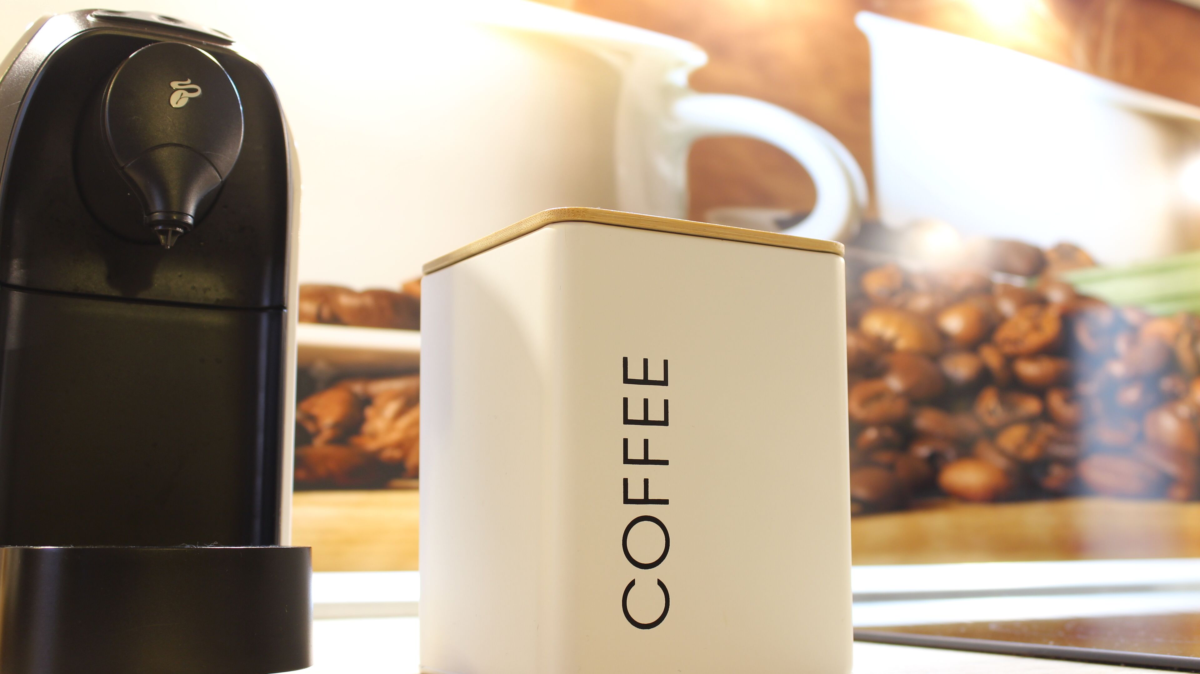 A coffee maker and a coffee pod box on a table.