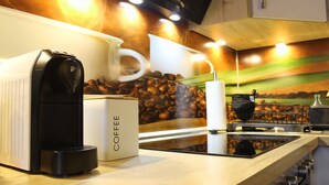 Een koffieapparaat, een houder voor koffiecups en een kop koffie op een aanrecht, met een achtergrond van koffiebonen.