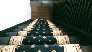 A staircase with patterned carpet leading to a room. - The Arundel Room in historic Holladay House (Orange)