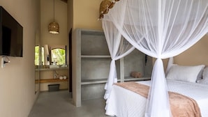Ein Schlafzimmer mit Baldachinbett, Nachttisch, Spiegel und Regal mit Dekoration.
