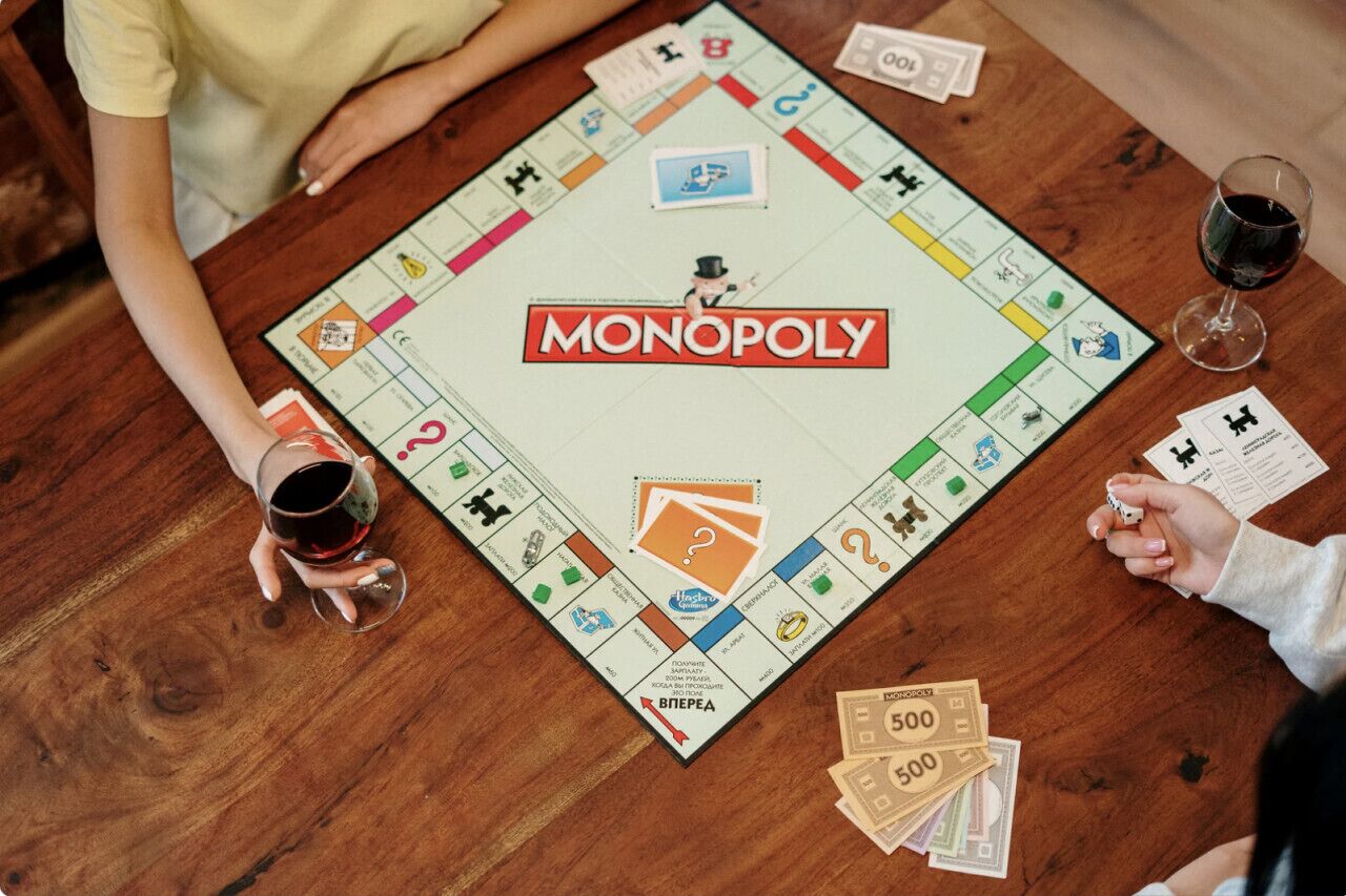 Un juego de Monopoly sobre una mesa de madera con dinero y fichas.
