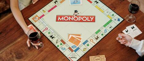 Un juego de Monopoly sobre una mesa de madera con dinero y fichas.